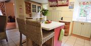 A view of the kitchen with breakfast bar and pink and green decor