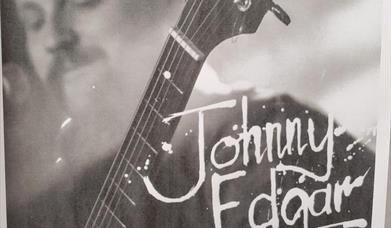Black and white photo of JE playing guitar