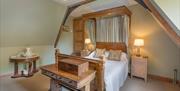 Period beamed Victorian bedroom furnished in the style of the era with one double bed and furniture