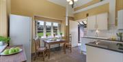Light airy kitchen with cream walls, white worktops and ceiling with a table for two