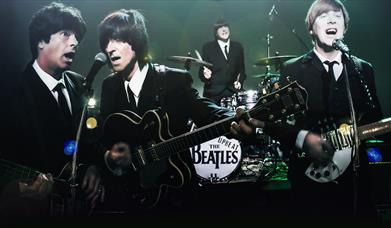 The Upbeat Beatles - photograph of tribute band as the Beatles playing instruments