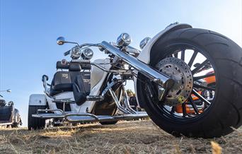 Very low viewpoint of a large silver motor trike