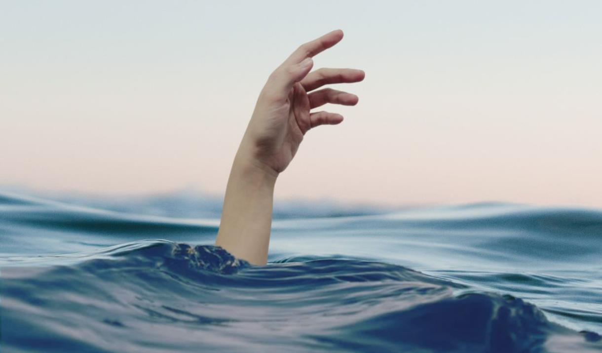 A single hand rising out of an ocean