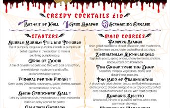Menu for three course meal. At the top a black graveyard with tombstones and the sun setting behind it. The title is blood red and white for the price