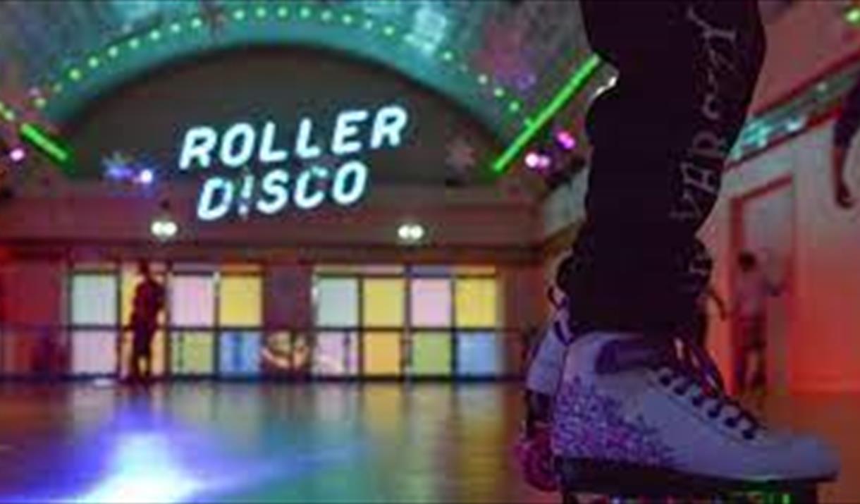 A room set up for roller disco with skater's feet in foreground