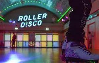 A room set up for roller disco with skater's feet in foreground