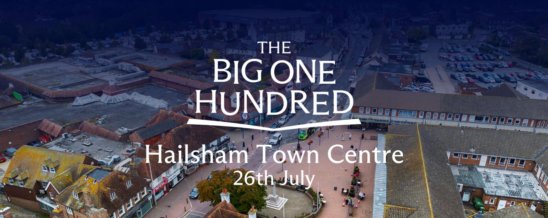Aerial view of Hailsham Town Centre showing streets, shops and a central square, with “The Big One Hundred – Hailsham Town Centre 26th July” text overlaid.