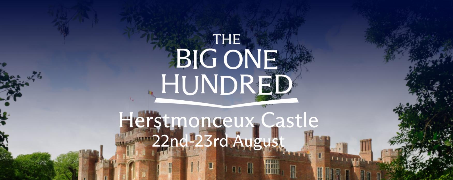 Herstmonceux Castle reflected in the moat, surrounded by greenery, with “The Big One Hundred – Herstmonceux Castle 22nd–23rd August” text overlaid.