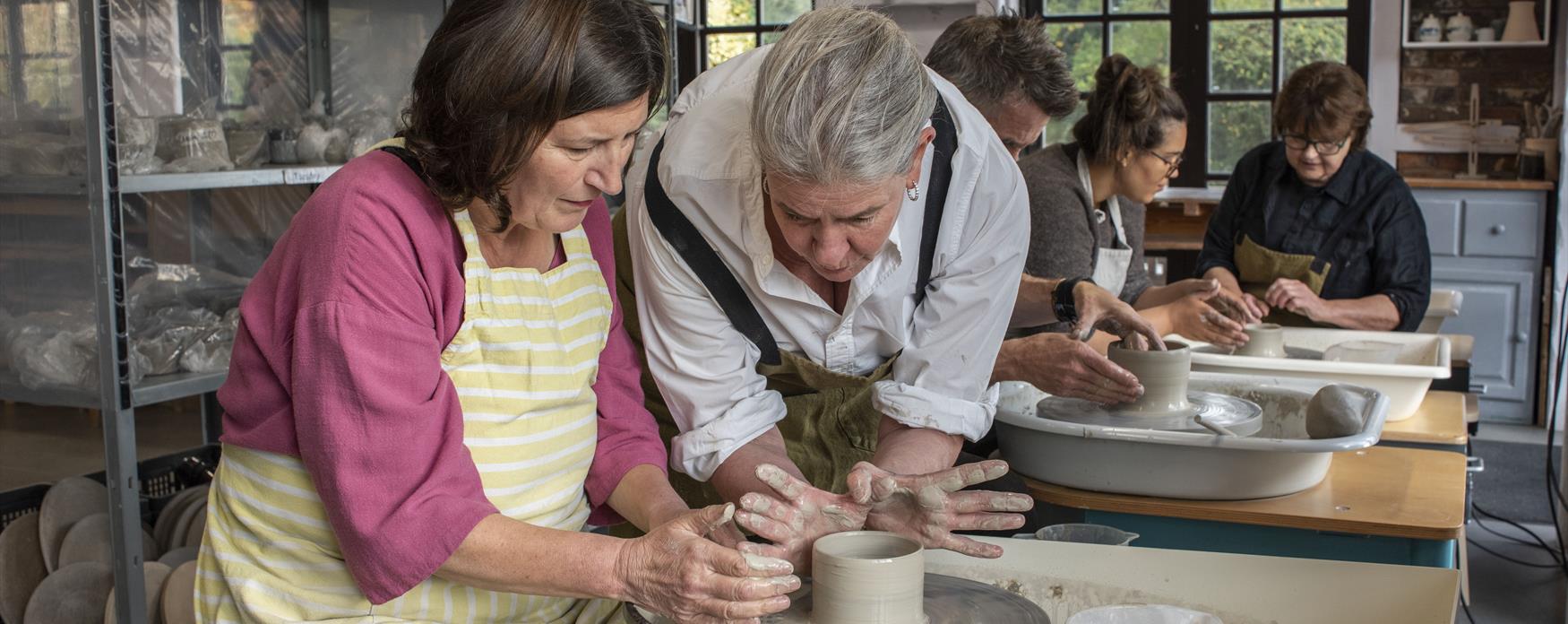 Someone learning how to make pottery in a studio