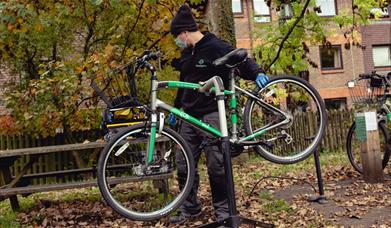 man with face mask and green bike on bike stand