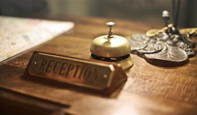 reception desk with sign and bell