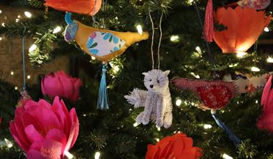 A Christmas tree decorated with a wolf and handmade flowers.