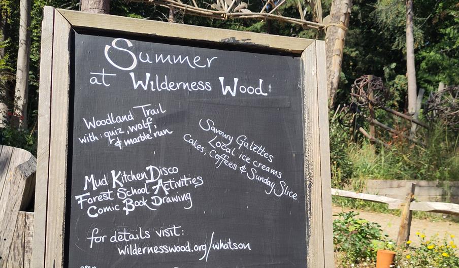A blackboard with a description of upcoming activities, and a picture of a sunshine with a face