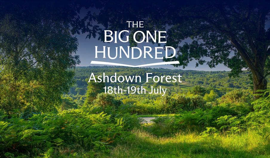 Panoramic view of Ashdown Forest with lush green woodland and rolling hills, framed by trees, with “The Big One Hundred – Ashdown Forest 18th–19th Jul