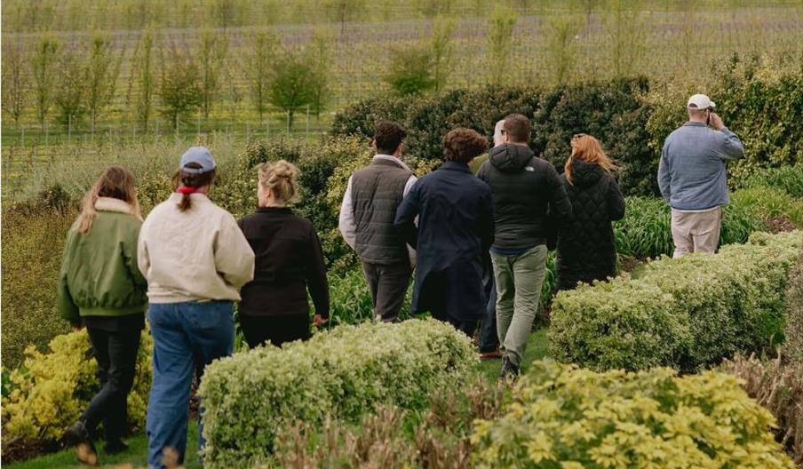 Image of a group walking through the gardens of the vineyard at Rathfinny