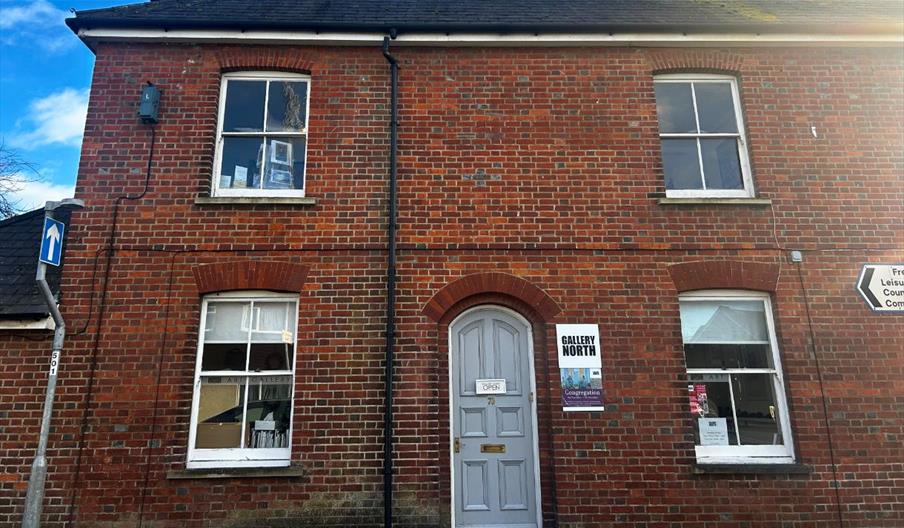 a red-brick building, with a sign reading "Gallery North" on the right-hand side of the door