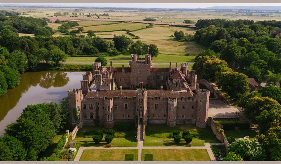 An ariel shot of Herstmonceux Castle, a red-brick castle surrounded by a moat