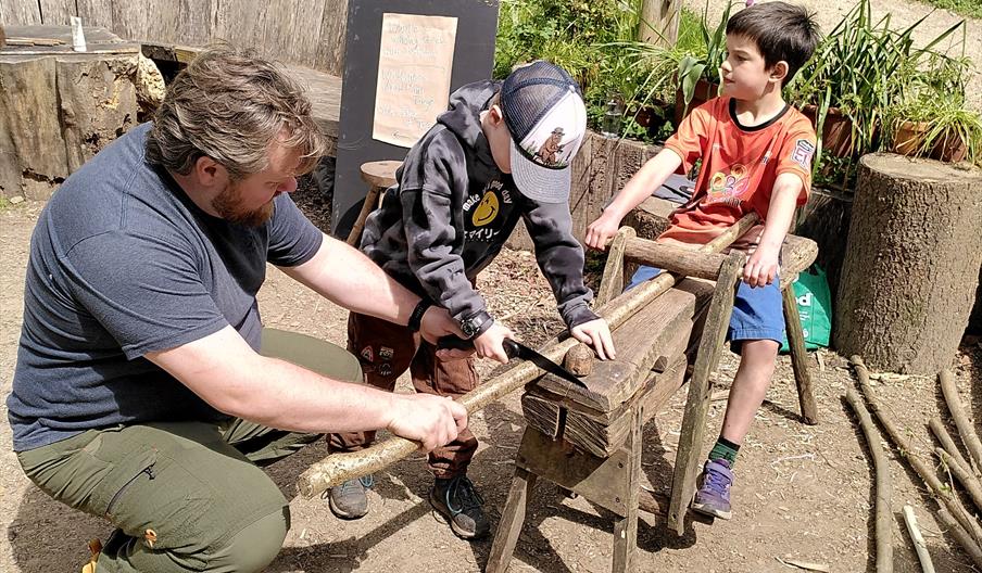 A family making chestnut pegs on a traditional shave horse