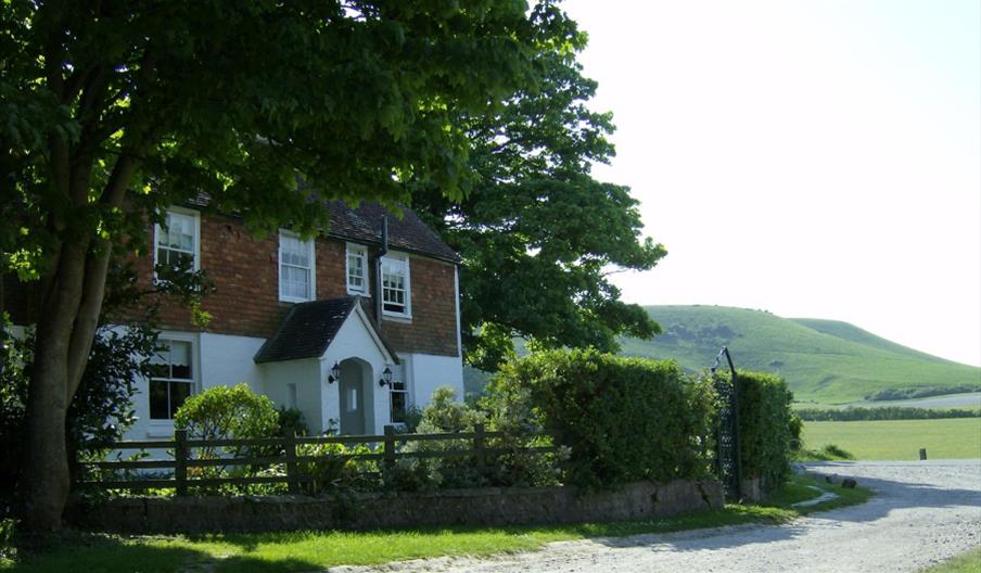 The white farmhouse with glorious green hills behind