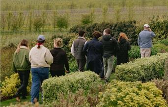 Image of a group walking through the gardens of the vineyard at Rathfinny