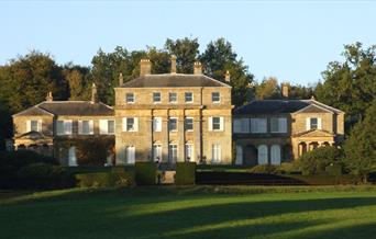 an impressive house with 3 buildings over 3 floors stood behind green gardens