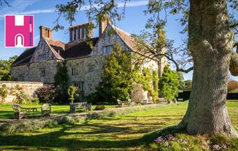 Bateman's house with greenery climbing up the side, and a tree in the right hand corner