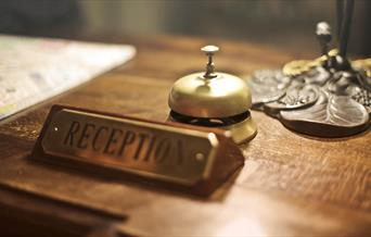 reception desk with sign and bell