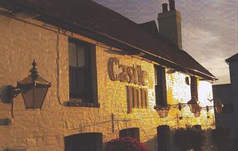 The outside of the Castle Inn pub at dusk.