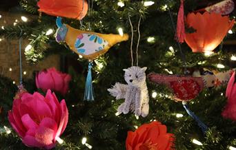 A Christmas tree decorated with a wolf and handmade flowers.