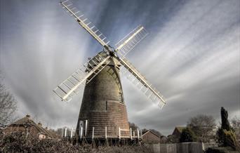 brick windmill with white sails