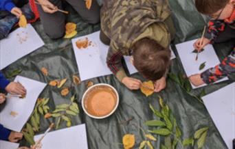 kids making creative pieces with leaves and paint