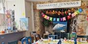 A children's party table laid out with a happy birthday banner in the background
