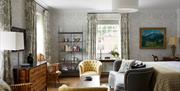 Double bedroom with grey couch and two yellow chairs