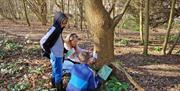 Image of two boys and their mother looking for clues along the trail