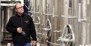 Image of a man walking through the tanks that make wine