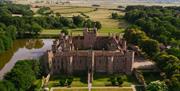 An ariel shot of Herstmonceux Castle, a red-brick castle surrounded by a moat