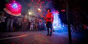 Remembrance-themed display at the East Hoathly Carnival and Bonfire celebrations, featuring a large illuminated poppy, torchbearers and falling red pe
