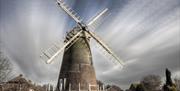 brick windmill with white sails