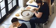 Image of three people making pottery