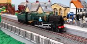 A lego train sitting on a train track at a lego station
