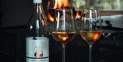 Image of two glasses of Birchden Vineyards wine infront of a fire