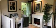 A table and chairs, fireplace, and a front door