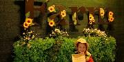 A logo of Sharnfold farm with a happy child in front of it with a certifcate