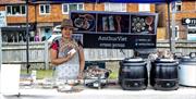 An AmthucViet food van with a woman showing her leaflets