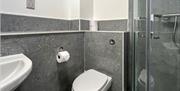 A bathroom with a toilet, shower and sink.