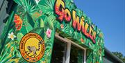 Entrance to Go Wild! in Heathfield, decorated with vibrant tropical artwork and Drusillas Family Theme Park branding.