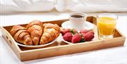 Breakfast tray of croissants and strawberries and drinks