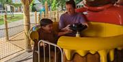 image of a boy and his mum sitting on the spinning honey pot bears ride