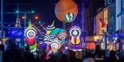 A street parade of giant inflatable puppets in the dark