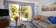 Living area with sofa, TV, and coffee table, with double patio doors